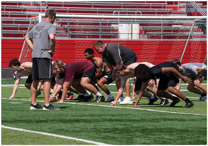 A group of football players wearing black and white uniforms. Description generated by AI