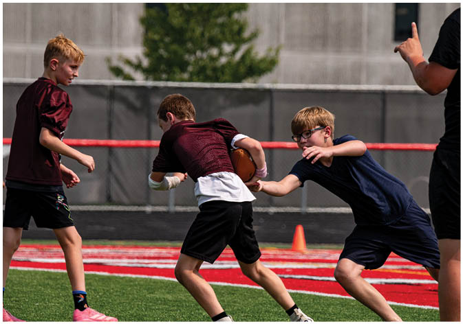 A group of football players wearing black and white uniforms. Description generated by AI