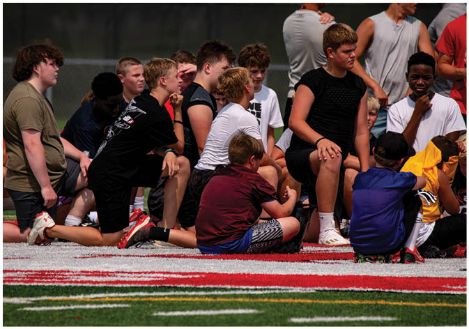 A group of football players wearing black and white uniforms. Description generated by AI