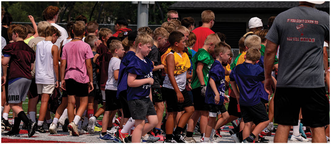 A group of football players wearing black and white uniforms. Description generated by AI