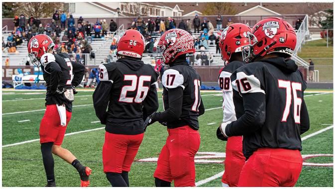 A group of football players on a field. Description generated by AI