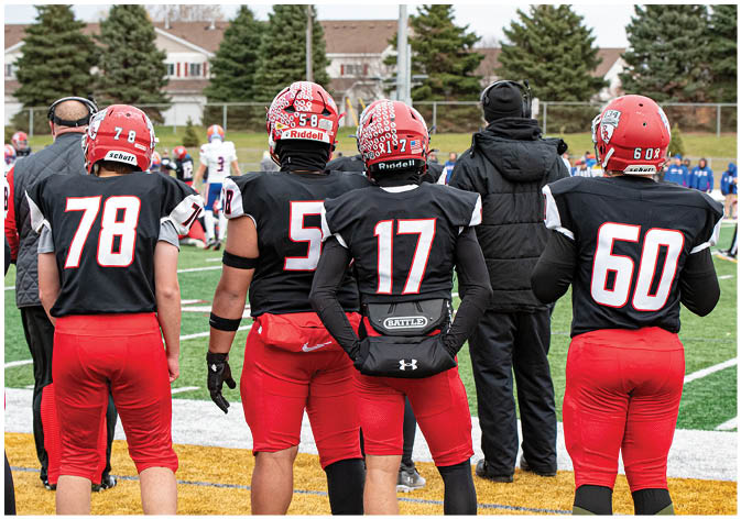 A group of football players wearing black and white uniforms. Description generated by AI