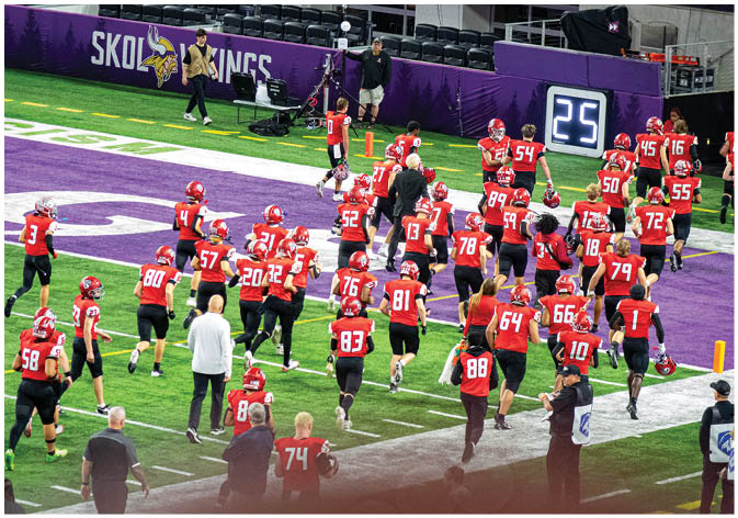 A group of football players wearing black and white uniforms. Description generated by AI