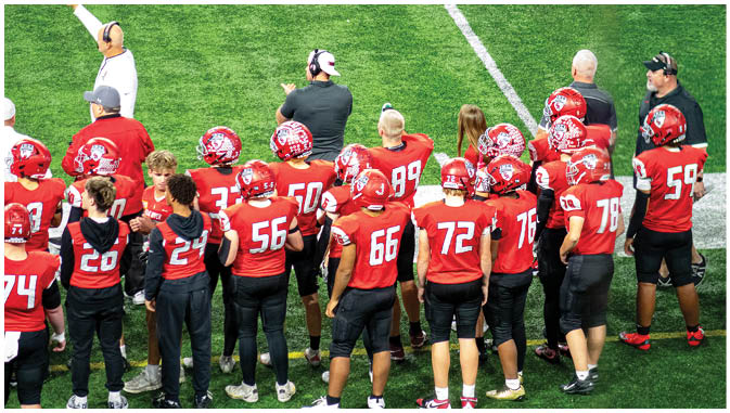 A group of football players on a field. Description generated by AI