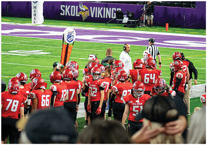 A group of football players wearing black and white uniforms. Description generated by AI