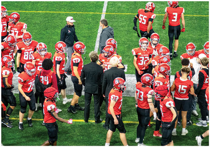 A group of football players wearing black and white uniforms. Description generated by AI