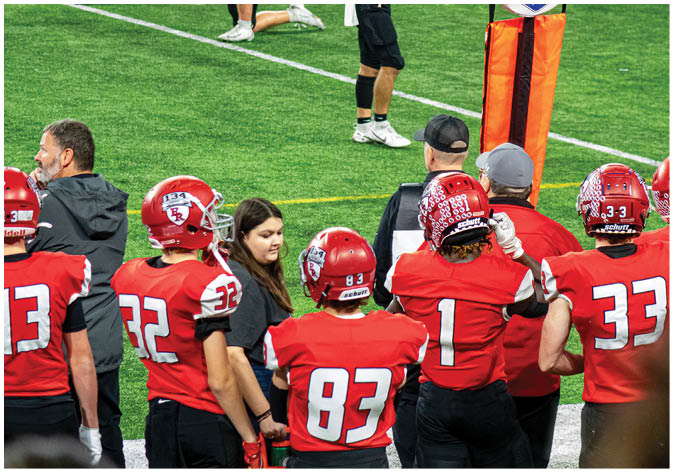 A group of football players wearing black and white uniforms. Description generated by AI