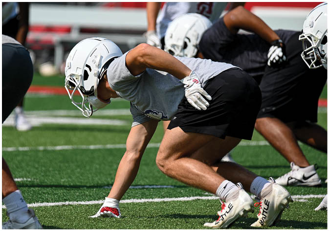 A group of football players wearing black and white uniforms. Description generated by AI