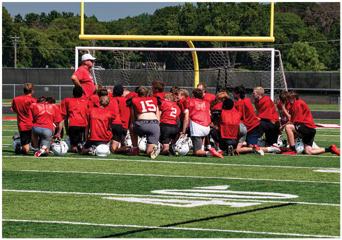 A group of football players wearing black and white uniforms. Description generated by AI