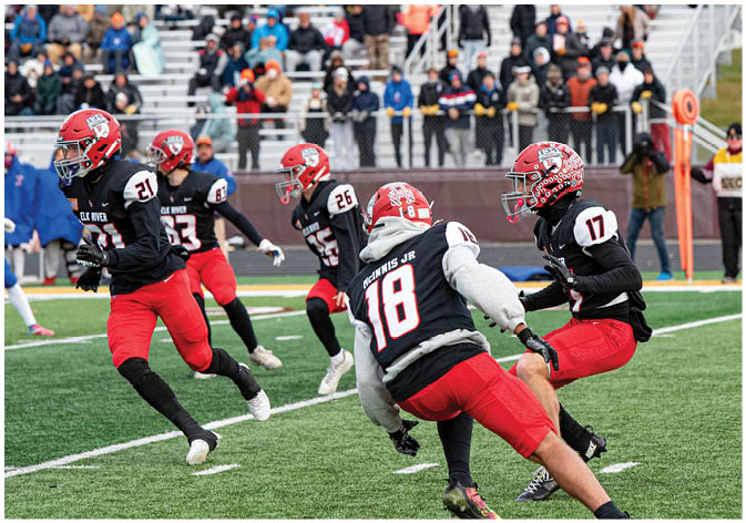 A group of football players wearing black and white uniforms. Description generated by AI