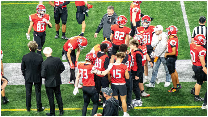 A group of football players on a field. Description generated by AI