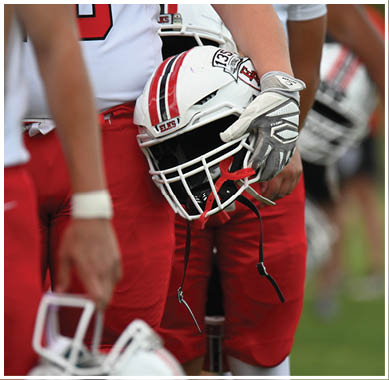 A football game is taking place with a group of men on the field. Description generated by AI