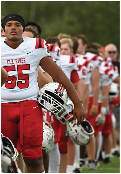 A football player wearing a blue and red jersey. Description generated by AI