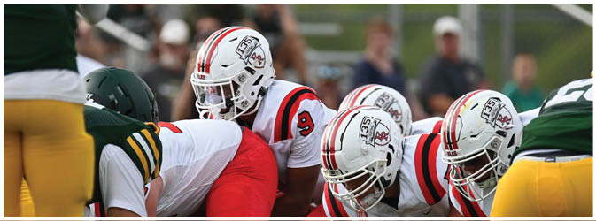 A football game is taking place on a field with players wearing blue and white uniforms. Description generated by AI