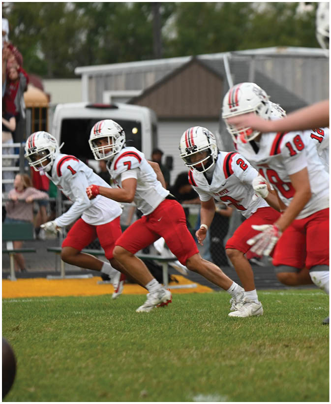 A group of football players on a field. Description generated by AI