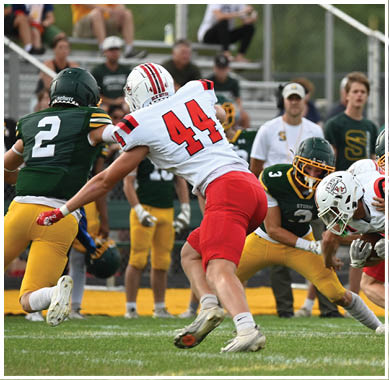 A football game is taking place with a group of men on the field. Description generated by AI
