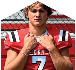 A young man wearing a white jersey with the number 10 on it. Description generated by AI