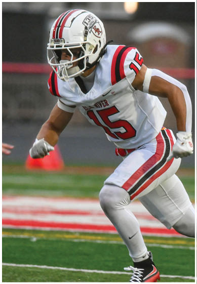 A football player wearing a blue and red jersey. Description generated by AI