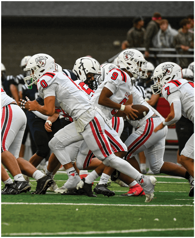 A group of football players on a field. Description generated by AI