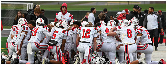 A group of football players on a field. Description generated by AI