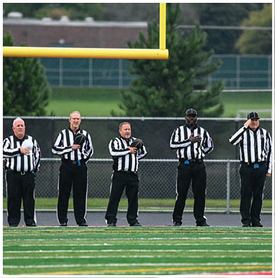 A football game is taking place with a group of men on the field. Description generated by AI