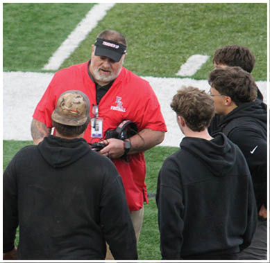 A football game is taking place with a group of men on the field. Description generated by AI