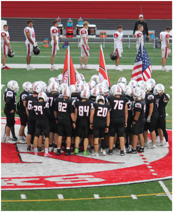 A group of football players on a field. Description generated by AI