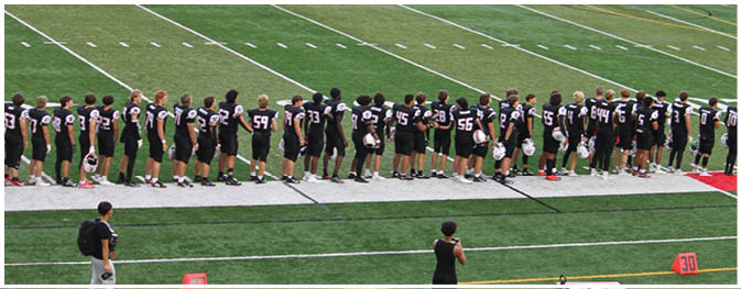 A group of football players on a field. Description generated by AI