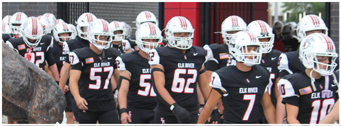 A football game is taking place on a field with players wearing blue and white uniforms. Description generated by AI