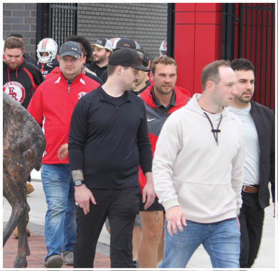 A football game is taking place with a group of men on the field. Description generated by AI