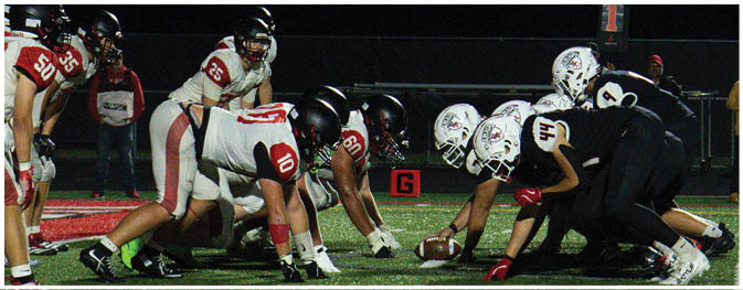 A group of football players on a field. Description generated by AI