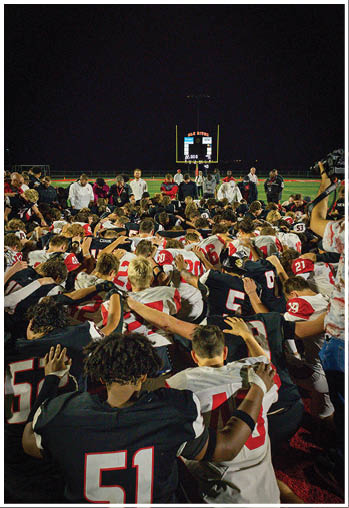 A group of football players celebrating a touchdown. Description generated by AI