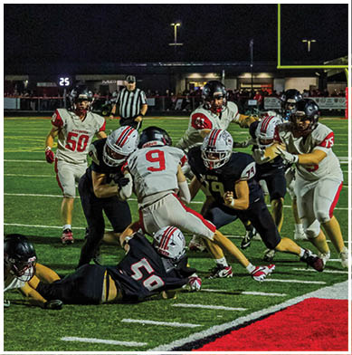 A football game is taking place with a group of men on the field. Description generated by AI