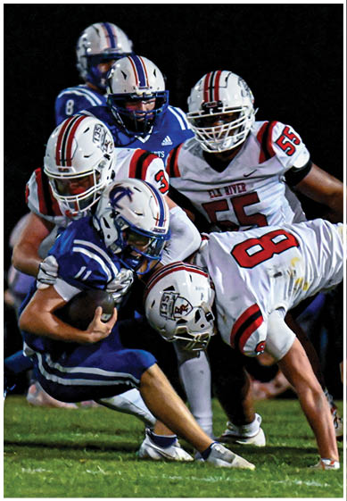 A football player wearing a blue and red jersey. Description generated by AI