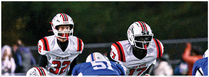 A football game is taking place on a field with players wearing blue and white uniforms. Description generated by AI