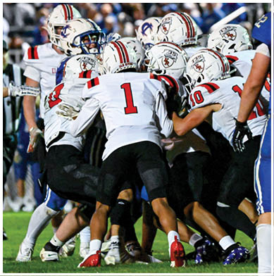 A football game is taking place with a group of men on the field. Description generated by AI