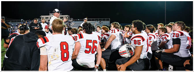 A football game is taking place on a field with players wearing blue and white uniforms. Description generated by AI