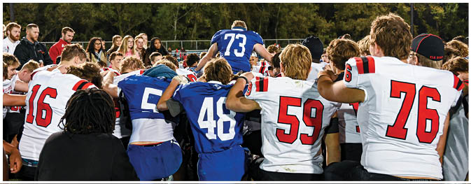 A group of football players on a field. Description generated by AI