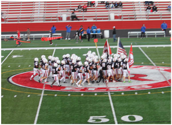 A group of football players on a field. Description generated by AI
