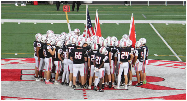 A football game is taking place on a field with players wearing blue and white uniforms. Description generated by AI