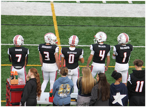 A group of football players on a field. Description generated by AI