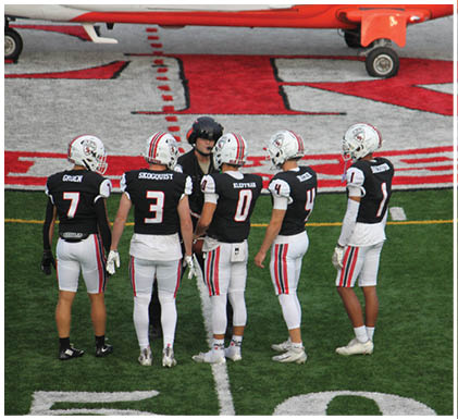 A group of football players celebrating a touchdown. Description generated by AI
