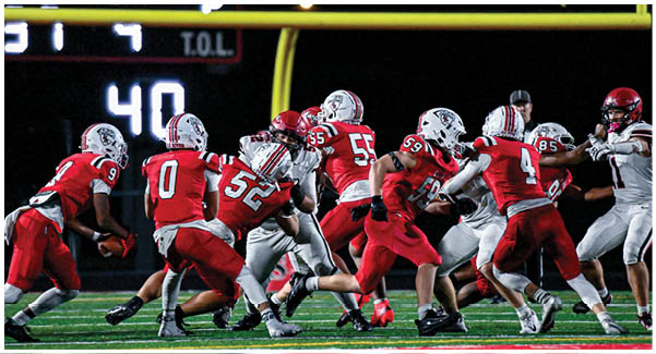 A football game is taking place on a field with players wearing blue and white uniforms. Description generated by AI