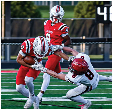 A football game is taking place with a group of men on the field. Description generated by AI