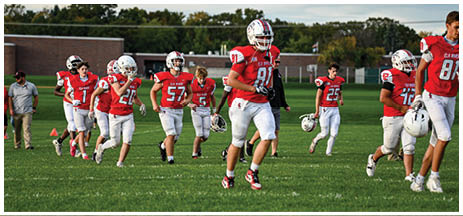 A football player running on the field. Description generated by AI