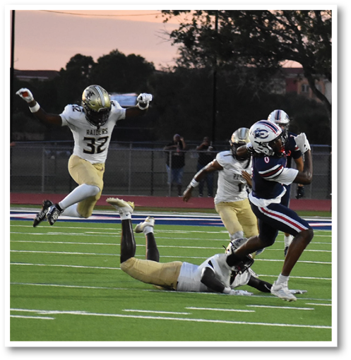 A person in a dark sports uniform is running on a football field while another person in a light uniform is falling to the ground after attempting a tackle. Description generated by AI
