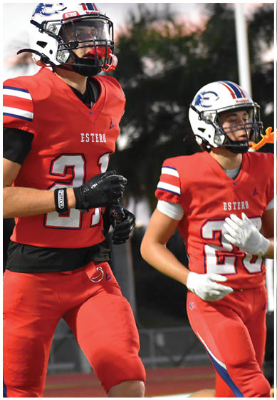 People wearing football uniforms with “W Wildcats" on the pants are standing closely together on a field. Description generated by AI