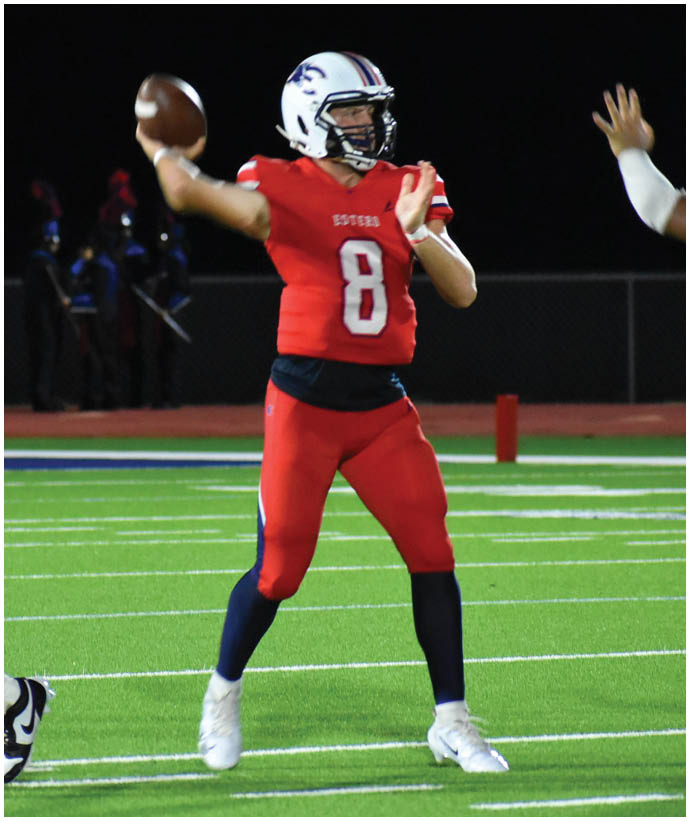 People in football uniforms are on a field at night, with one person wearing number 9 and another wearing number 8 engaging in a celebratory gesture. Description generated by AI