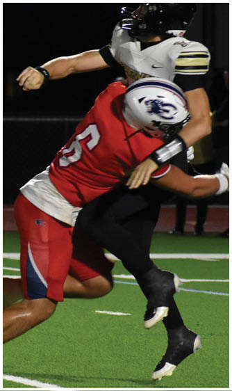 Two people wearing white football uniforms with black and red accents are standing on a grassy field during a game. Description generated by AI