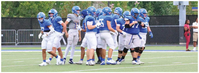 A football player wearing a blue and white uniform. Description generated by AI